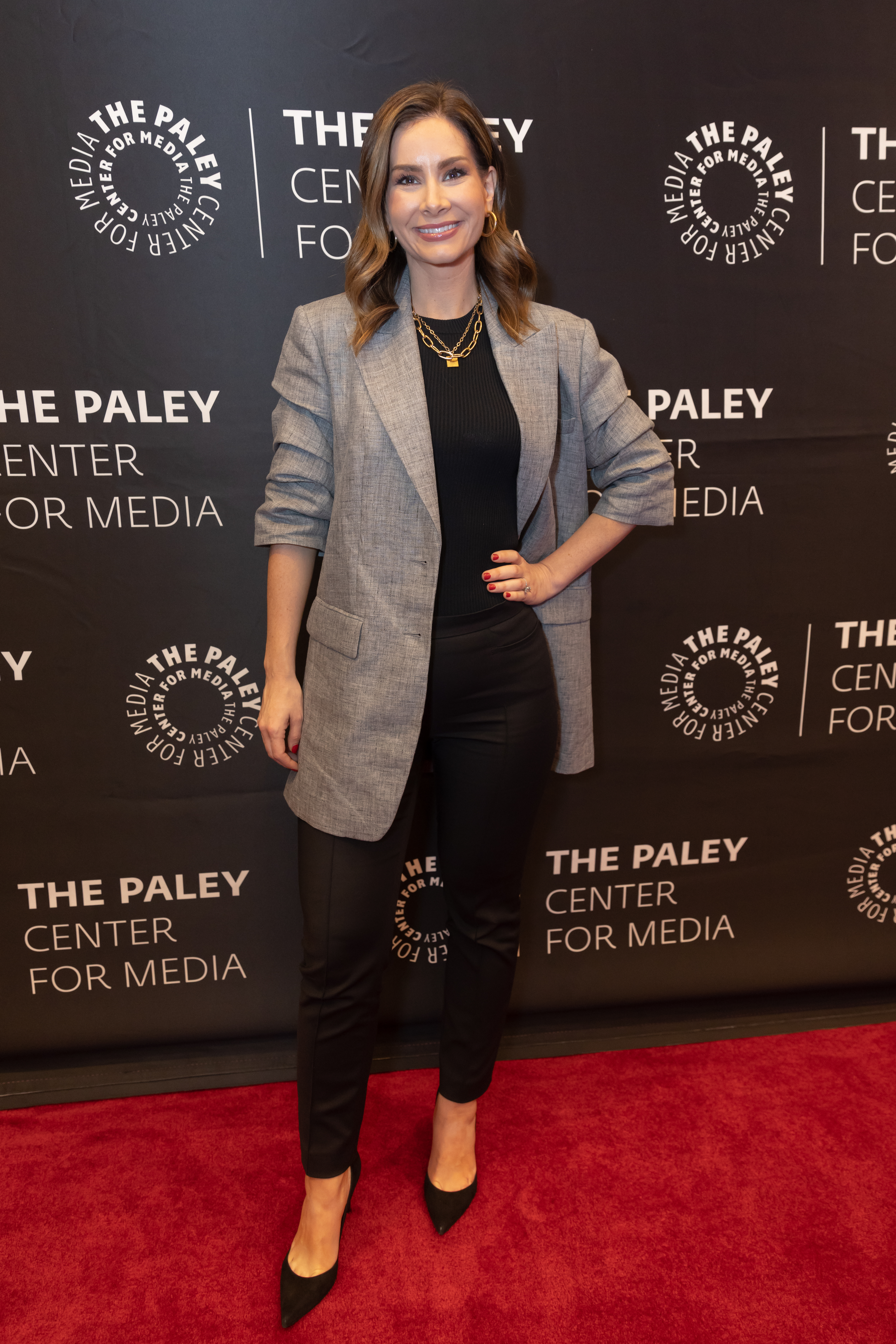 Rebecca Jarvis wears black outfit and gray blazer no red carpet