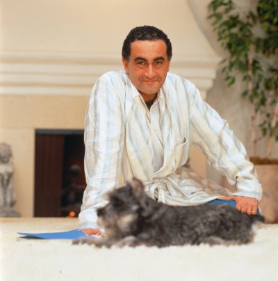 Dodi Fayed sits on the ground with his dog