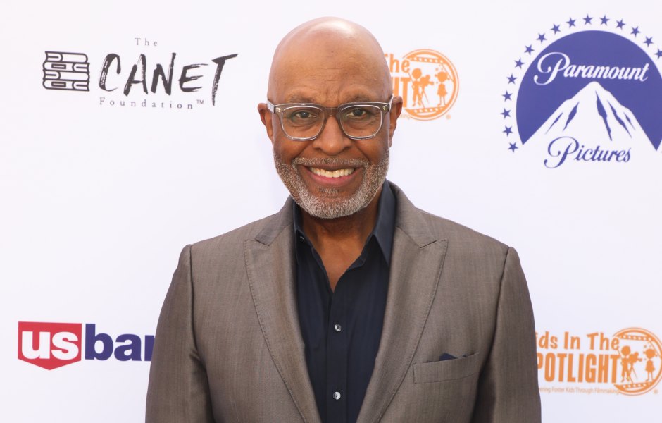 James Pickens Jr. smiles while wearing a gray suit with a black shirt