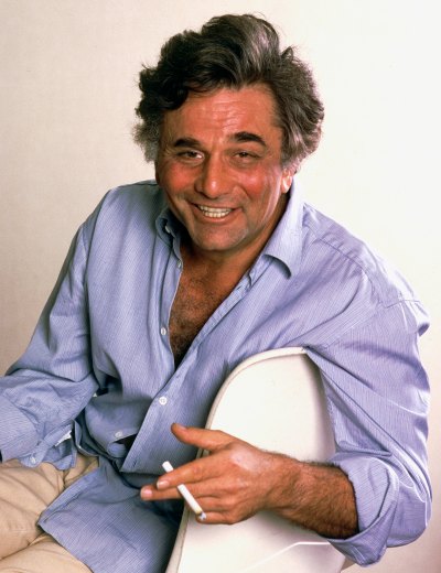 Peter Falk smiles in portrait while smoking a cigarette