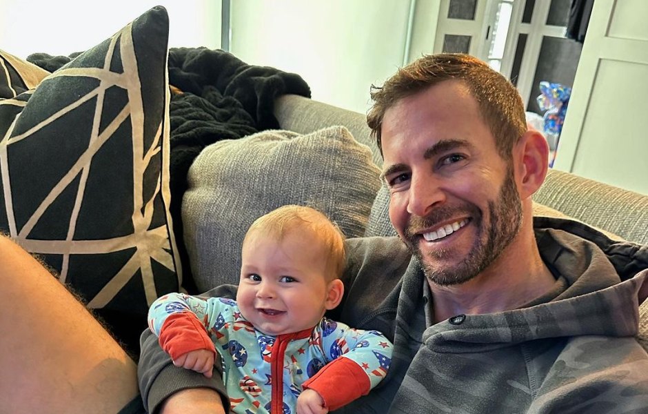 Tarek El Moussa holds son Tristan in his arms while sitting on couch
