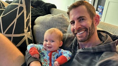 Tarek El Moussa holds son Tristan in his arms while sitting on couch