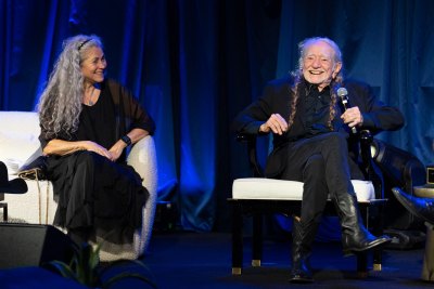 Willie Nelson sits on stage next to wife Annie D'Angelo