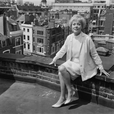 Glynis Johns sitting on a rooftop