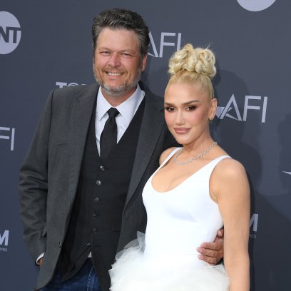 Gwen Stefani smiles in a white and green gown with Blake Shelton