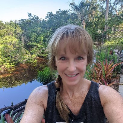 Karen E. Laine takes a selfie in front of plants