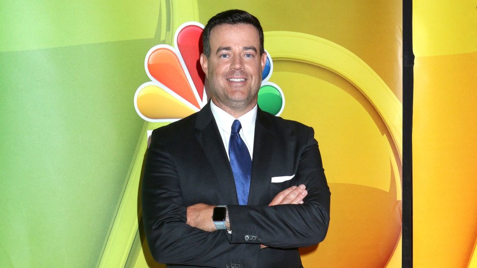 Carson Daly wears black suit with blue tie