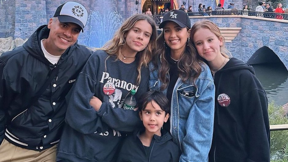Jessica Alba and her family standing in front of castle at Disneyland