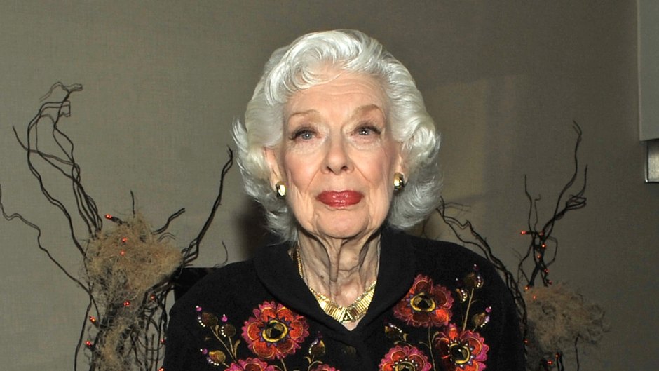 Joyce Randolph wears a black shirt with floral embroidery