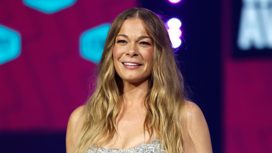 LeAnn Rimes stands on stage in a silver lace gown