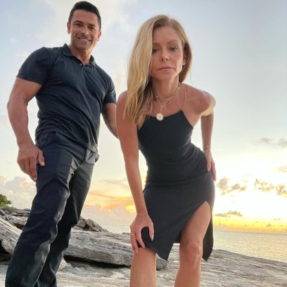 Kelly Ripa and Mark Consuelos pose together while standing on a rock