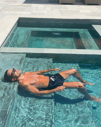 Mark Consuelos floats in a pool while shirtless