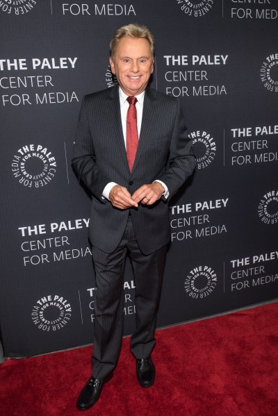 Pat Sajak on red carpet with a black suit and red tie