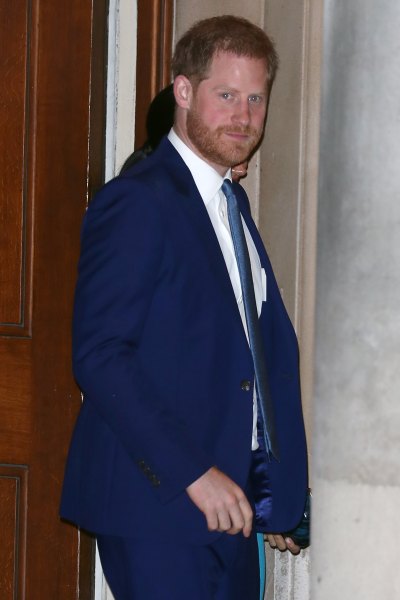 Prince Harry walking in a navy suit 