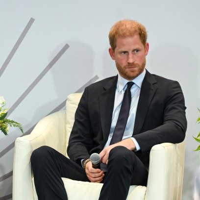 Prince Harry wears black suit while sitting in white chair