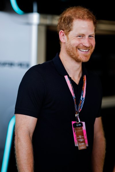 Prince Harry smiles in a black shirt 