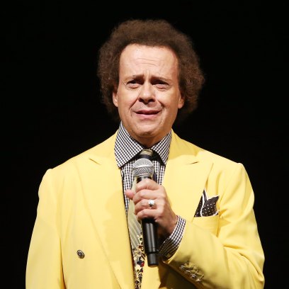 Richard Simmons in a yellow blazer holding a microphone