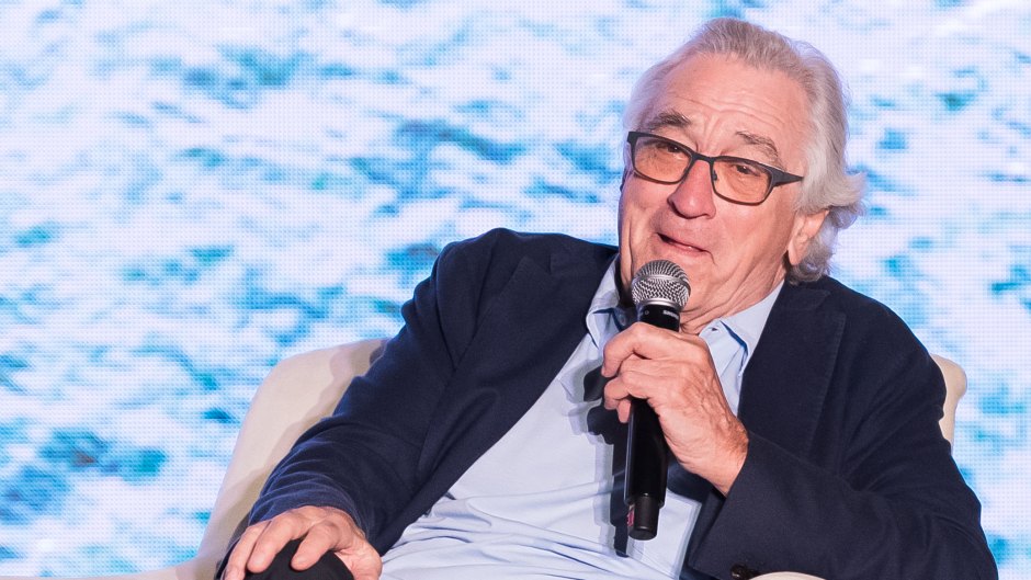 Robert De Niro sits in chair with microphone