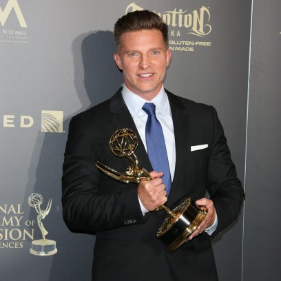 Steve Burton wears black suit with tie while holding Emmy